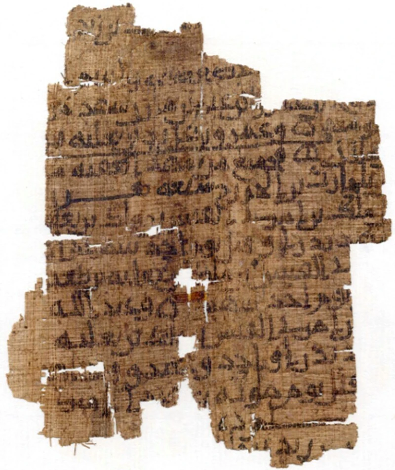 A ragged fragment of brown papyrus with losses along its edges and two holes near the centre, carrying about ten lines of early Arabic script in dark ink